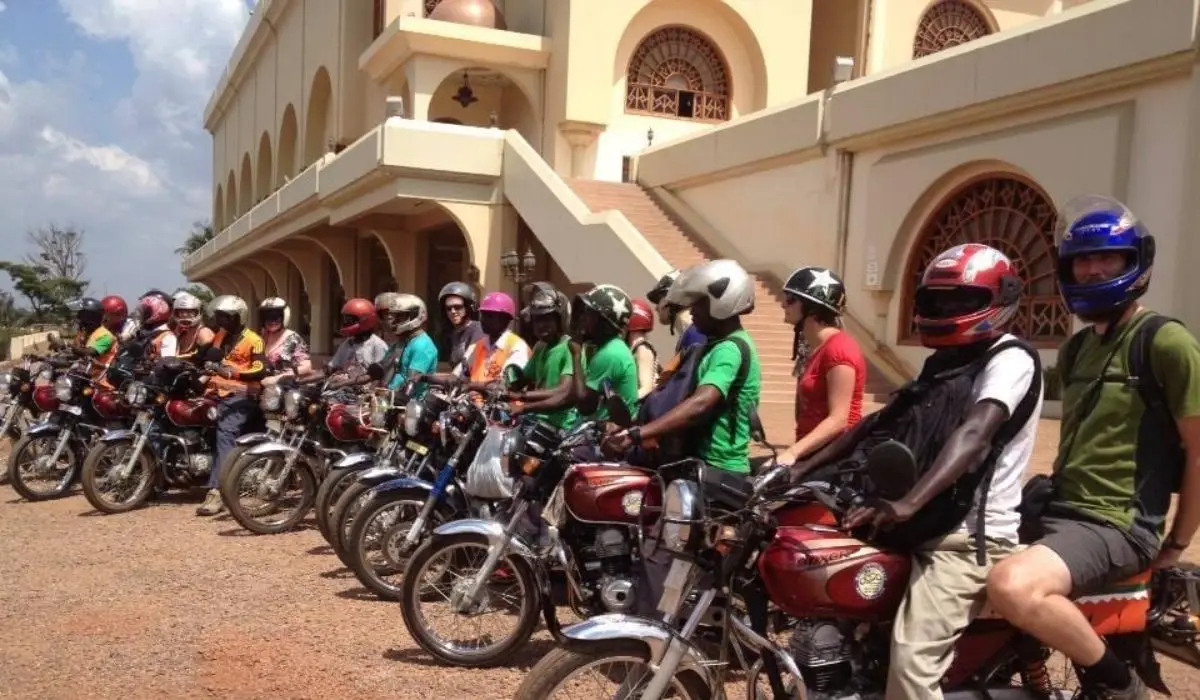 Guests and riders lined up on motorcycles outside a Kampala building